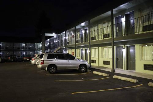 a car parked in a parking lot in front of a building at Tiki Lodge Motel in Spokane