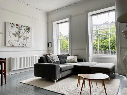 a living room with a couch and a table at Grand & Graceful One Bed Flat in Clifton Village in Bristol
