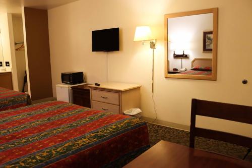 a hotel room with two beds and a mirror at Tiki Lodge Motel in Spokane