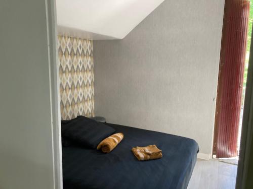 a bedroom with a blue bed with a towel on it at Appartement La Libellule, professionnels et vacanciers in Compreignac