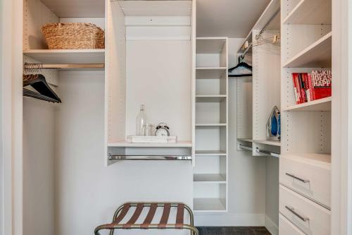 a walk in closet with a stool and shelves at Reno Townhome with Mountain-View Rooftop Deck! in Reno