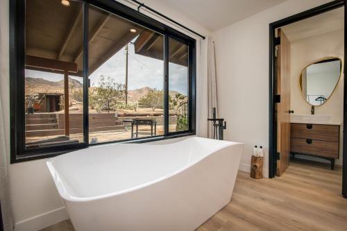 a bath tub in a bathroom with a large window at @ Marbella Lane - The Wine Mine Desert Escape in Joshua Tree