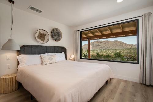 a bedroom with a large bed and a large window at @ Marbella Lane - The Wine Mine Desert Escape in Joshua Tree
