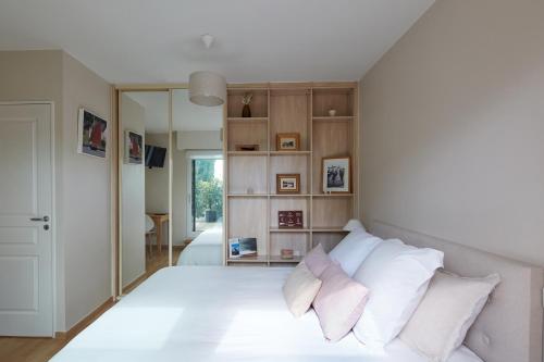 um quarto com uma cama branca e almofadas brancas em Un Appartement PENTHOUSE d'Exception sur le Port de Vannes em Vannes