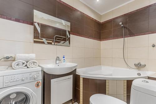a bathroom with a sink and a washing machine at Sea View Studio in Arkadia in Odesa