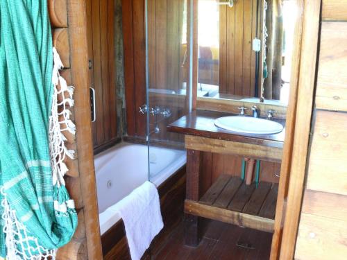 y baño con lavabo, ducha y bañera. en Cabañas de la Ribera en San Pedro