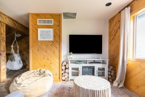 a living room with a flat screen tv on a wall at Whispering Hollow Lodge on Greer Main St! in Greer
