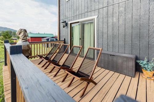 a row of chairs sitting on a deck at Whispering Hollow Lodge on Greer Main St! in Greer