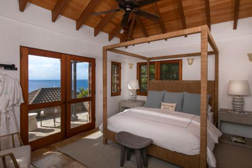 a bedroom with a bed and a view of the ocean at Lovango Resort and Beach Club in Cruz Bay