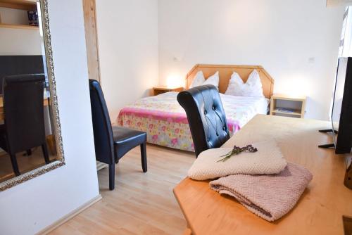 a bedroom with a bed and a table with a mirror at Pension Froschkönig in Forchheim