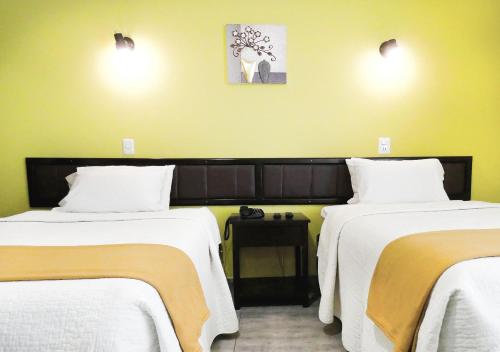 a hotel room with two beds with white sheets at Hotel Plaza in Tacna