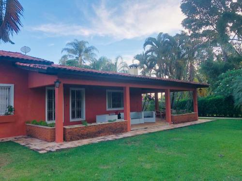 una casa roja con un pabellón en un patio en Casa na Represa do Broa - Condomínio Vila Pinhal en Itirapina