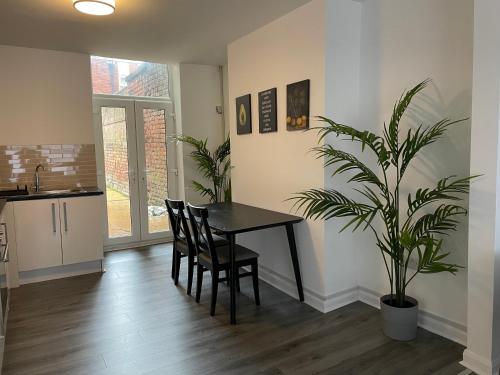 a dining room with a table and a potted plant at City Stays in Liverpool