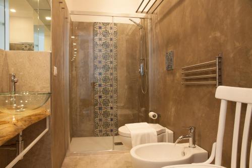 a bathroom with a shower and a toilet and a sink at A Tonnara in Cefalù