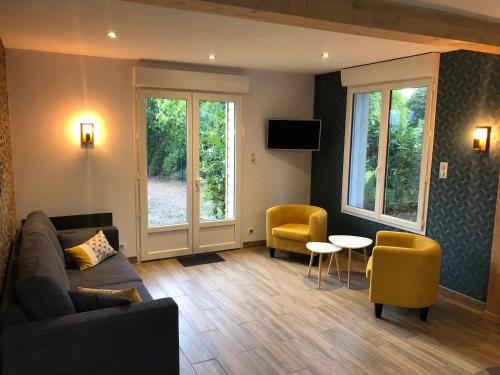 un salon avec un canapé, une table et des chaises dans l'établissement Maison cosy entièrement rénovée, à Aumale