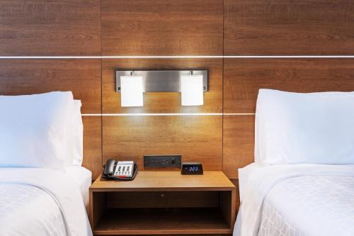 a hotel room with two beds and a phone on a table at Holiday Inn Express & Suites - Denton - Sanger by IHG in Sanger