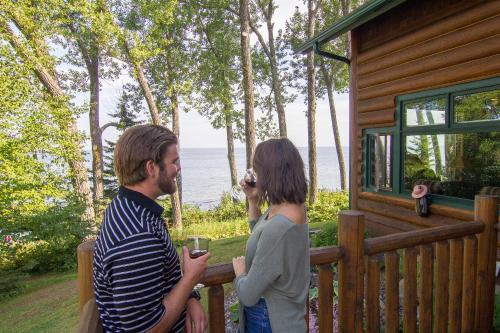 a man and a woman standing on a fence near a cabin at Grand Superior Lodge in Castle Danger