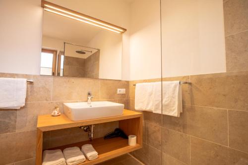 een badkamer met een wastafel en een spiegel bij Lahnhof in Lana