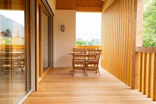 a wooden porch with chairs and a table at Lahnhof in Lana