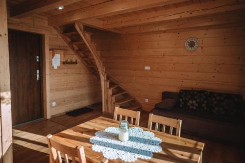 a wooden room with a table and chairs and a staircase at Domek w Korycie -Apartament 5-7 osobowy, Apartament 2 osobowy in Koniaków