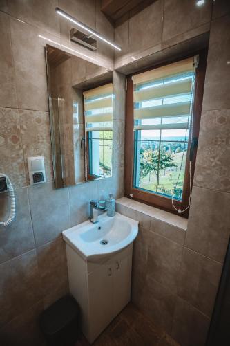 a bathroom with a sink and a mirror and a window at Domek w Korycie -Apartament 5-7 osobowy, Apartament 2 osobowy in Koniaków