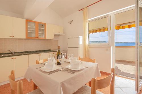 a dining room with a table with a white table cloth at Sladana direckt at the Beach in Metajna