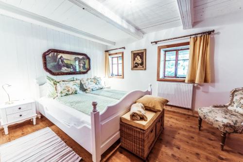 um quarto com uma cama branca e uma cadeira em Haus zur alten Bimmelbahn em Kurort Jonsdorf
