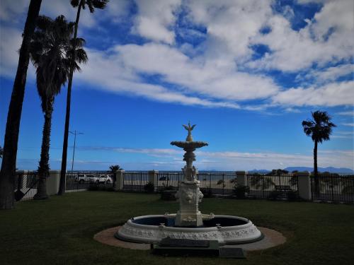 a fountain in the middle of a park with palm trees at On The Beach At Strand in Strand