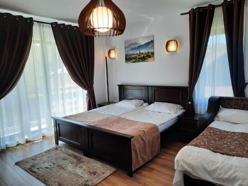 a bedroom with two beds and a large window at Sat de Vacanta Martisorul Cacica in Suceava