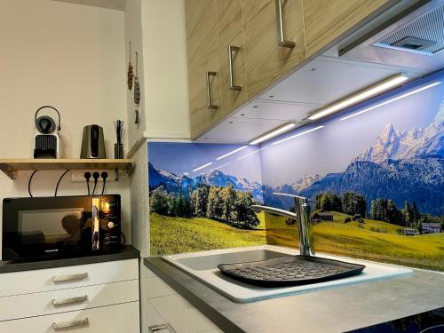 une cuisine avec une fresque murale représentant les montagnes. dans l'établissement L'AnsloBoys Montagne H2, à Les Deux Alpes