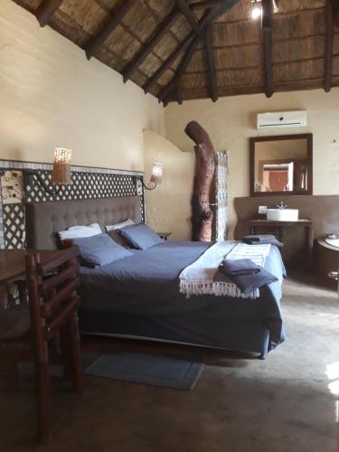 a bedroom with a bed and a table and a mirror at African Silhouette Guesthouse in Benoni