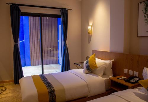 a hotel room with two beds and a window at VANCII Hotel in Chefchaouene