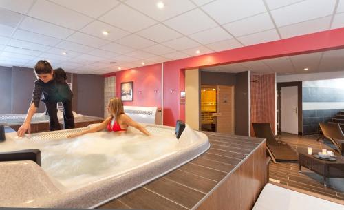 a woman and a child in a hot tub at Hôtel Club mmv Les Mélèzes **** in Arc 2000