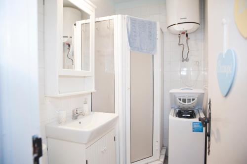 Baño blanco pequeño con lavabo y espejo en Helios Chaparral, en Costa del Silencio