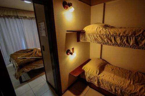 a bedroom with two bunk beds and a mirror at Residencial Pousada do Serrano - 1 quarto in Gramado