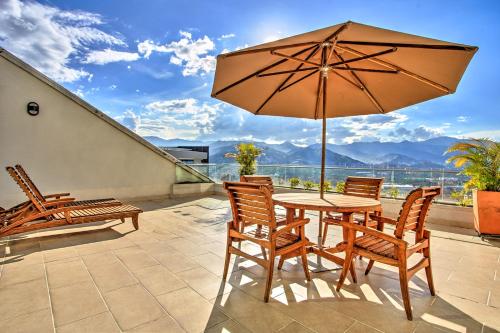 a patio with a table and chairs and an umbrella at Hotel San Fernando Plaza in Medellín