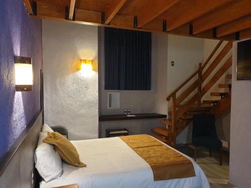 ein Schlafzimmer mit einem Bett und einem Treppenaufgang in der Unterkunft Hotel Don Carlos in Morelia