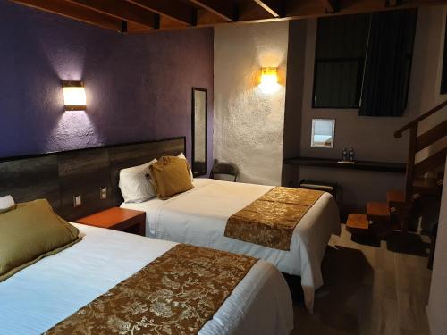 a hotel room with two beds and lights on the wall at Hotel Don Carlos in Morelia