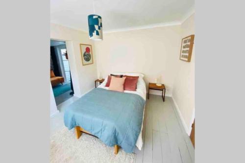 a bedroom with a bed with a blue blanket at The Yellow Door Whitstable - Peaceful retreat close to beach in Whitstable