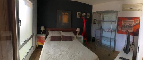 1 dormitorio con cama y pared negra en Suite Artigas, en Colonia del Sacramento