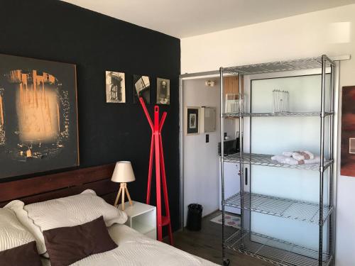 1 dormitorio con cama y estante con cinta roja en Suite Artigas, en Colonia del Sacramento