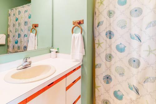 a bathroom with a sink and a shower curtain at Whitaker Escape #5HHH in Hatteras