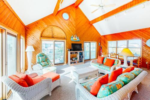 a living room with couches and a tv at Whitaker Escape #5HHH in Hatteras