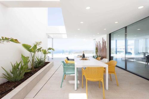 a dining room with a white table and chairs at "New Home Costa Adeje, Luxurious Private Villa" in Adeje