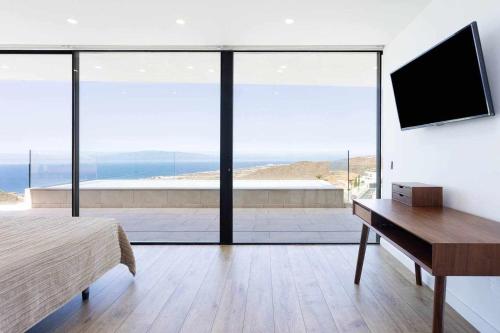 a bedroom with a bed and a desk with a television at "New Home Costa Adeje, Luxurious Private Villa" in Adeje