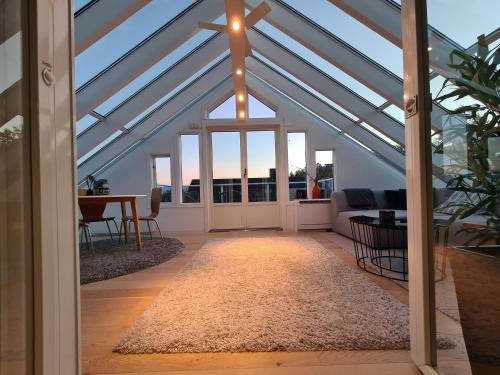 a conservatory with a glass roof with a living room at Glass roof private loft in Tromsø in Tromsø