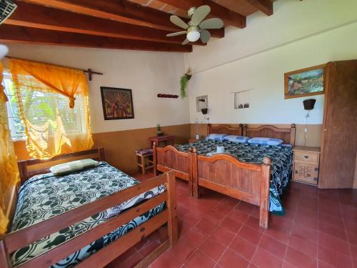 een slaapkamer met 2 bedden en een plafondventilator bij Posada El paraíso in Tepoztlán