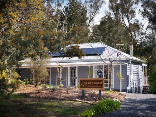 a white house with a sign in front of it at Lakewood minutes walk to Lake Daylesford in Daylesford