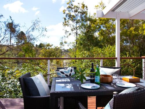 a table and chairs on a deck with a view at Lakewood minutes walk to Lake Daylesford in Daylesford