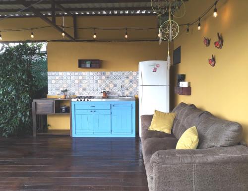 a living room with a couch and a blue kitchen at Dreamcatcher house in Sarchí